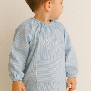 Baby escolar artesanal de rayas azules personalizado con el nombre Enzo bordado a mano en blanco, hecho en Don Botón.