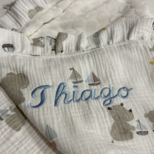 Arrullo artesanal para bebé personalizado con nombre Leire bordado a mano, hecho en Don Botón, tonos rosa empolvado y blanco.